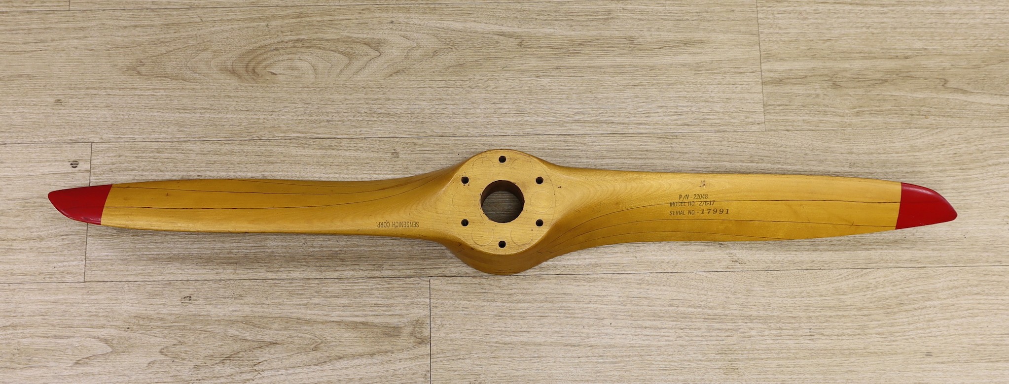 A Sensenich Corp laminated wooden propellor with red painted tips, P/N-22048, model no-276-17 serial no.-17991, 112cms long